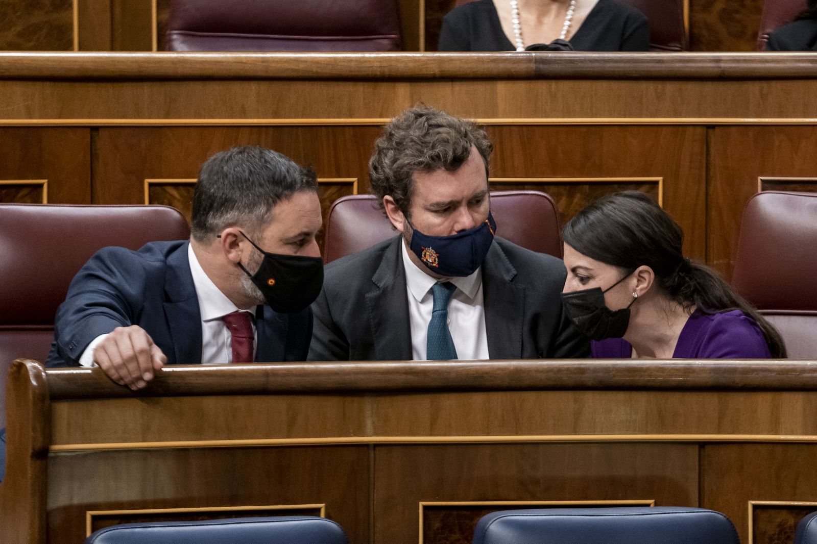 (I-D) El líder de Vox, Santiago Abascal; el portavoz parlamentario de Vox, Iván Espinosa de los Monteros; y la portavoz de Vox en el Congreso de los Diputados, Macarena Olona, conversan en una sesión plenaria, en el Congreso