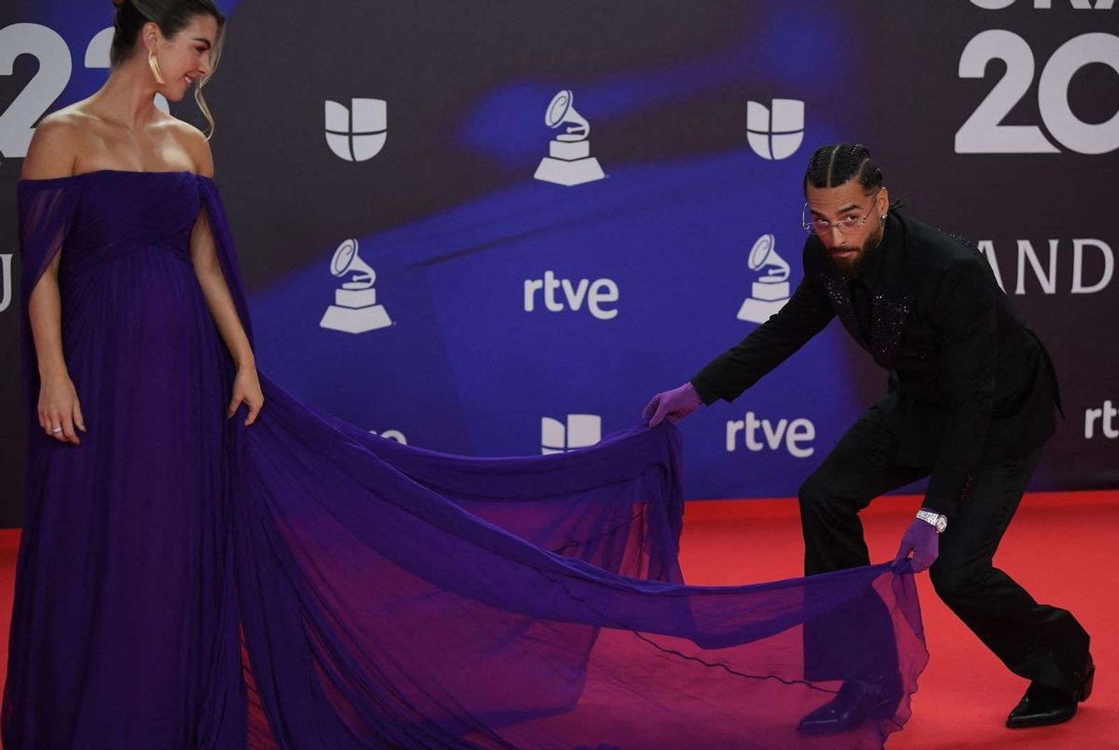 El cantante colombiano Maluma y su compañera Susana Gómez, a la que ayuda con la cola del vestido.