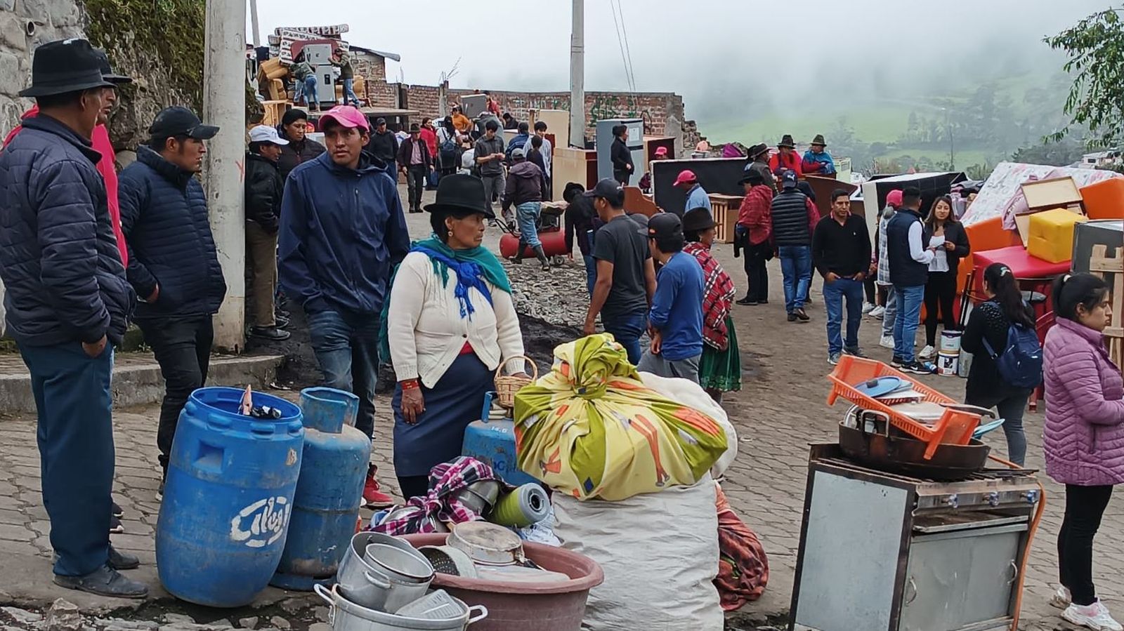Ciudadanos esperan junto a sus pertenencias en el cantón Alausí, en Chimborazo.